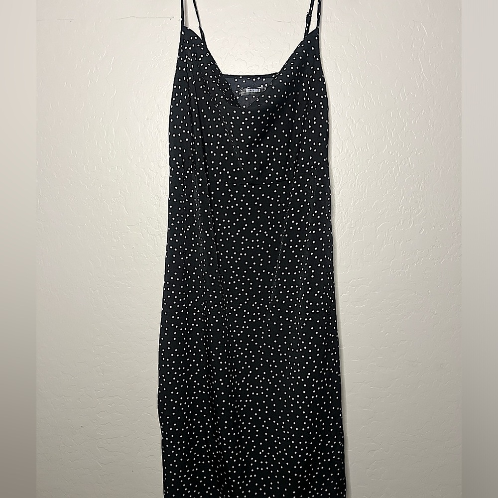 Adjustable spaghetti strap black slip dress with white polka dots.